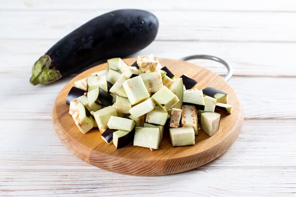 chopped eggplant and knife on cutting board on table - Драники из картофеля и баклажанов