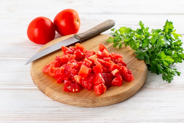 sliced tomato on a cutting board on a wooden table healthy veggie recipe - Овощной суп с баклажанами и чечевицей