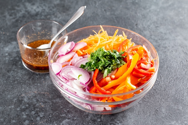sliced vegetables in a bowl for making a savory salad with bell peppers carrots vegetables and sesame seeds step by step recipe healthy food - Острый салат из болгарского перца с морковью и кунжутом