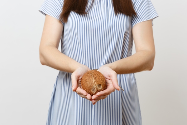 close up cropped photo woman in blue dress hold in hands coconut or exotic coco nut isolated on white background proper nutrition vegan vegetarian drink healthy lifestyle dieting concept copy space - Кокосовое молоко