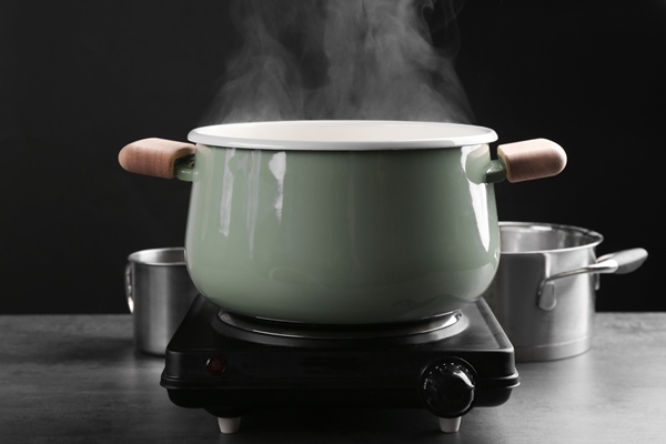 cooking rice in metal pan on hotplate in kitchen - Закуска овощная "Огонёк"