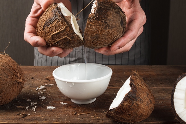 fresh coconut water pouring into white bowl - Кокосовое молоко