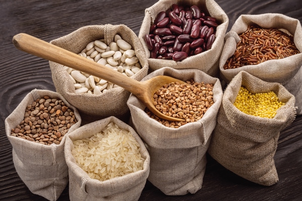 rice peas beans and cereals in bags wooden spoon close up - Растительное молоко: виды и свойства