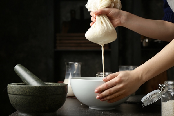 woman making healthy rice milk in kitchen - Рисовое молоко двумя способами