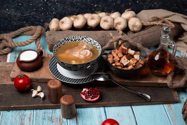 caucasian khash in bowl with yogurt crackers and tomatoes - Хаш