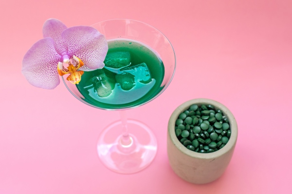 liquid spirulina green drink with phalaenopsis in cocktail glass and spirulina pills - Съедобные водоросли