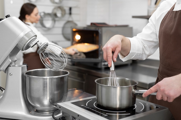 male pastry chef cooks a berry kuli in a saucepan for filling a cake - Молочный сахар