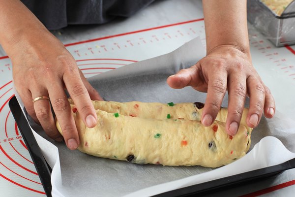 process rolling raw dough of christmas stollen german cake in the kitchen - Масляный рождественский штоллен