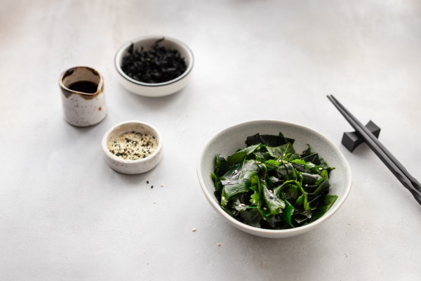 wakame seaweed in a bowl with sesame seeds - Съедобные водоросли