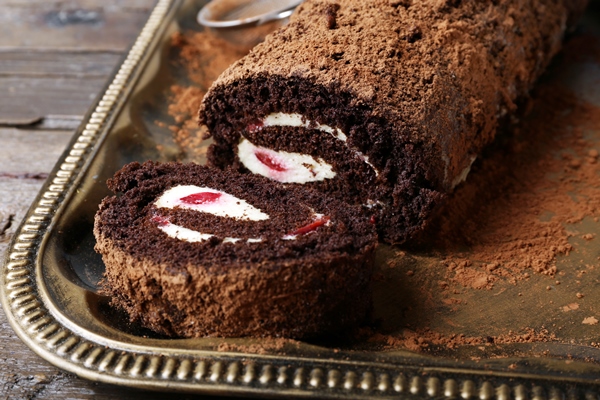 chocolate roll with cream and berries on table close up - Торт "Рождественское полено" с вишней