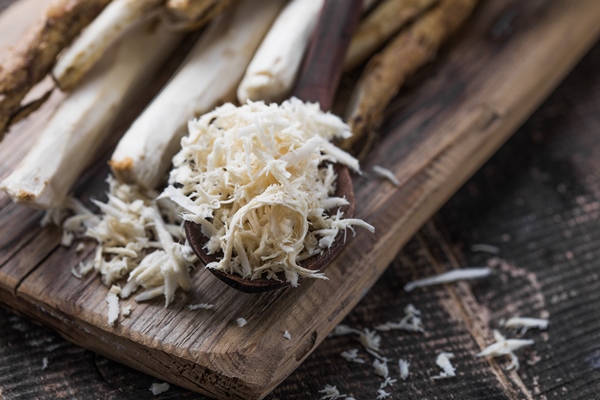fresh organic horseradish or horse radish root on wooden cutting board - Русский столовый хрен