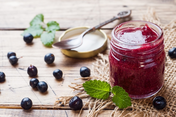 jar of homemade blueberry jam on a wooden surface - Ягодная холодная приправа
