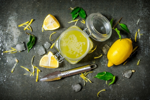 lemon juice in the jar with the zest leaves and ice around on the stone table top view - Русский столовый хрен