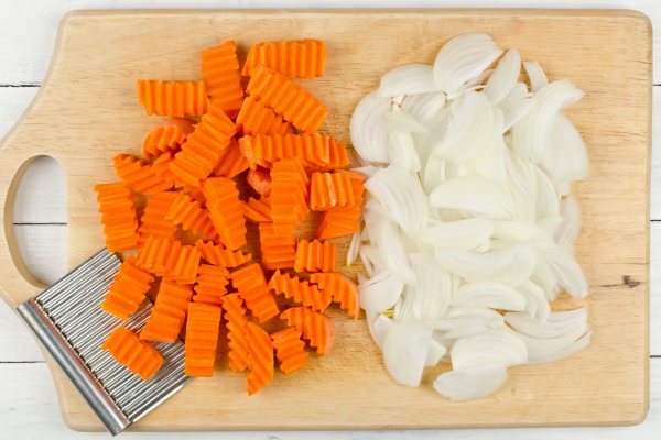 variously sliced for cooking carrots and onions on a cutting board - Мойва с овощами в горшочках
