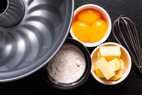 base of bakery preparation butter flour egg yolks on black slate stone - Пирог "Мечта" с яблоками