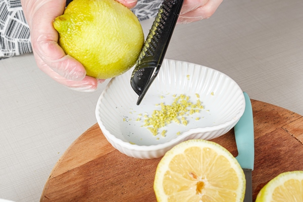 confectioner using a metal grater to scrape the lemon and pour it into the white chocolate ganache - Домашняя кулинарная соль