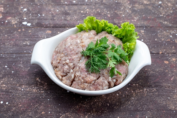 minced raw meat with greens inside plate on brown - Турецкая запеканка с кебабом