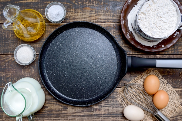 empty frying pan black for pancakes and ingredients on wooden background breakfast top view - Японские блины дораяки