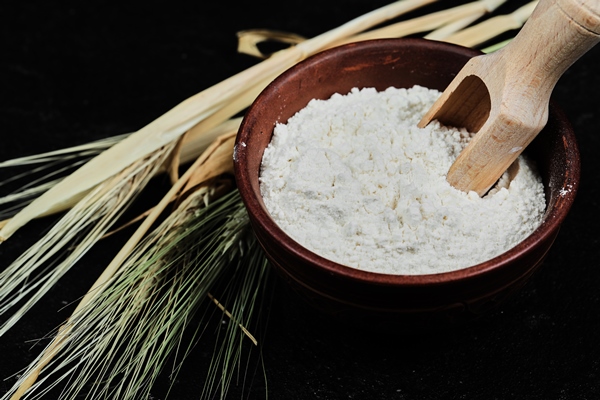 flour in bowl with wheat on dark table close up - Печёночный пирог с морковью и луком