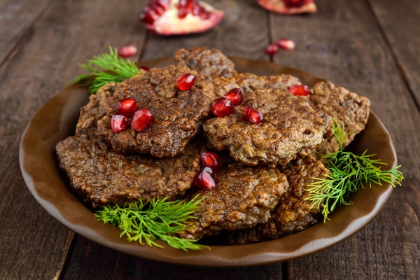 juicy liver cutlets with pomegranate seeds on a ceramic plate on a dark wooden background - Печёночные оладьи