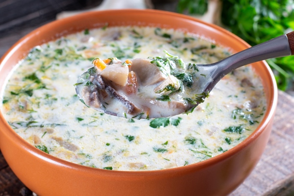 mushroom cheese soup in a bowl and ingredients on a wooden table vertical view from above close up 1 - Сырный суп с грибами и картофелем