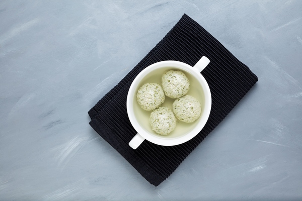 turkey meatballs with spinach in bone broth in white bowl - Мясное пюре для питания детей до 1 года