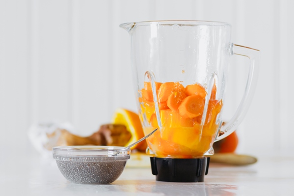 bowl with dry ingredient near blender - Постный смузи-боул из моркови и манго
