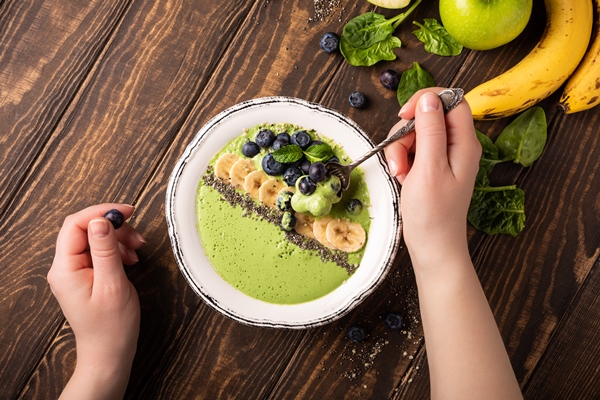 breakfast detox green smoothie bowl from banana and spinach on wooden surface 1 - Постный смузи-боул из бананов, яблок и шпината