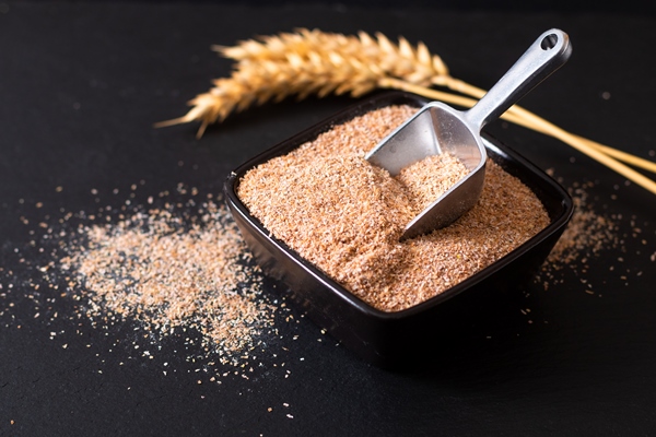 healthy food concept organic wheat bran in black ceramic cup with wheat ear on black slate stone - Постный тыквенный смузи