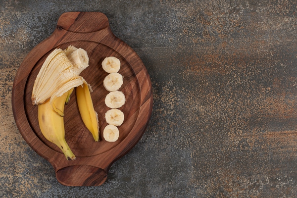 peeled and sliced banana on wooden board - Бананово-овсяный смузи на растительном молоке