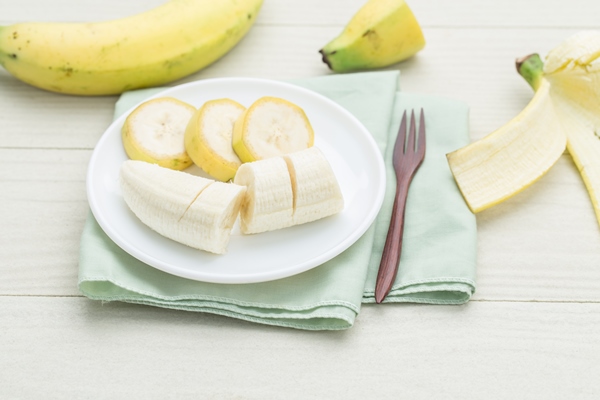 sliced banana on bowl on a white wooden table - Постный смузи-боул с зелёной гречкой