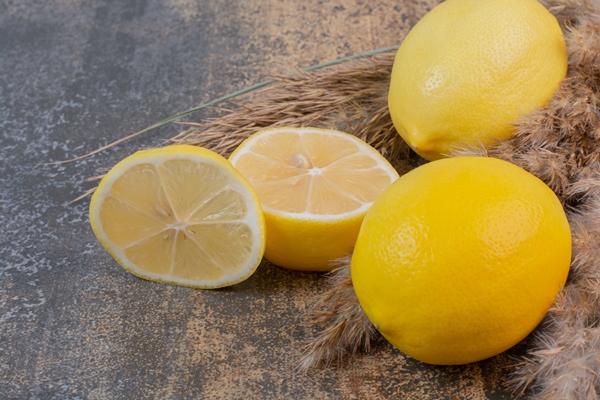 two whole fresh lemons with slice on marble space - Постный смузи-боул с ягодами асаи