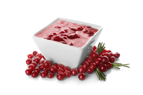 delicious cranberry sauce in bowl on white background - Драники с апельсиново-клюквенным соусом