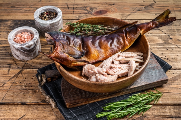 fillet of hot smoked fish pike perch or zander in a wooden plate with herbs wooden background top view - Консервирование пищевых продуктов