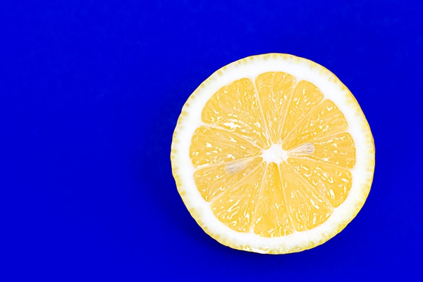 half a lemon on a blue background - Смузи-боул со шпинатом и авокадо