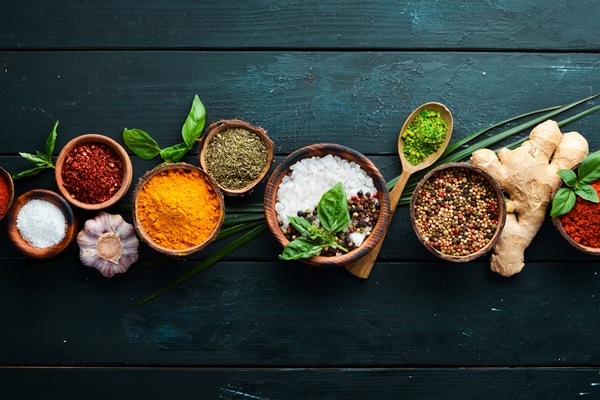 large spice and herb collection in bowls and spoons indian spices on a black wooden background top view - Драники с апельсиново-клюквенным соусом