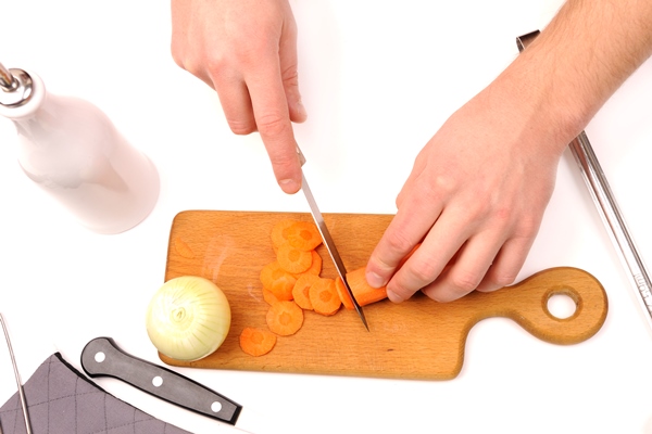 male hand cutting onions and carrot - Консервированная тушёная говядина с овощами в автоклаве