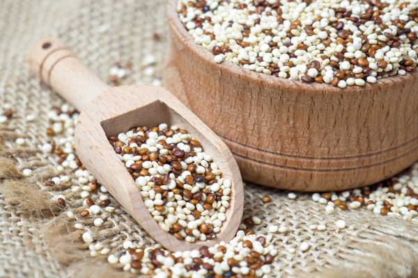 quinoa in wooden bowl and scoop on rustic background - Овощной салат с киноа