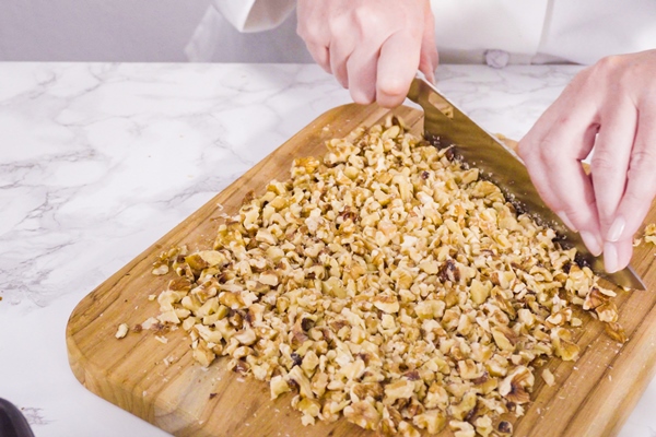 step by step chopping walnuts with kitchen knife on a wood cutting board - Диетическая творожная пасха
