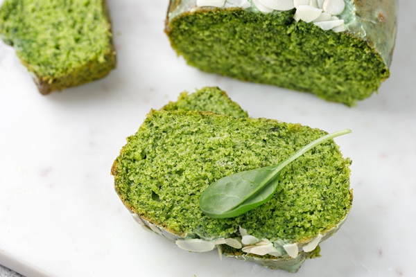 close up texture of pie sponge cake with spinach cutted on board grey background green cake - Использование в пищу огородной и дикорастущей зелени