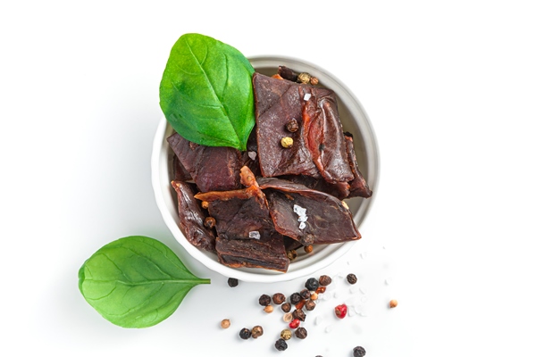 dried beef meat with spices and fresh basil in a bowl on white background - Подготовка к многодневному походу