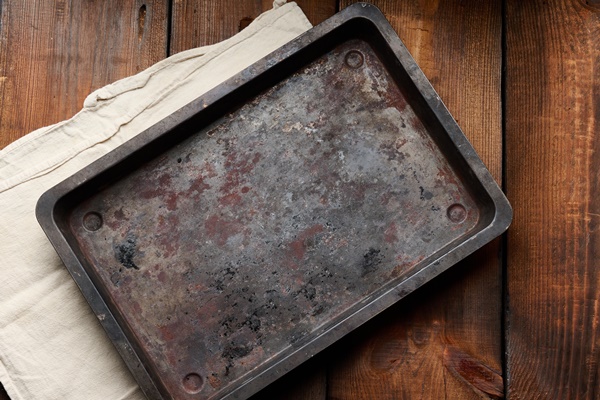 empty rectangular iron rusty baking sheet on a wooden brown table top view - Просфоры на заварной опаре