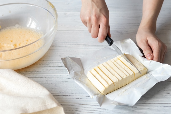 female hands slicing butter for homemade baking - Свадебный каравай