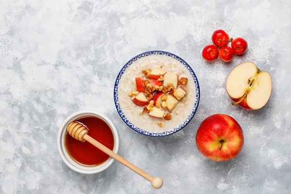 oatmeal porridge in a bowl with honey and red apple slices top view - Корневище кипрея (иван-чая)
