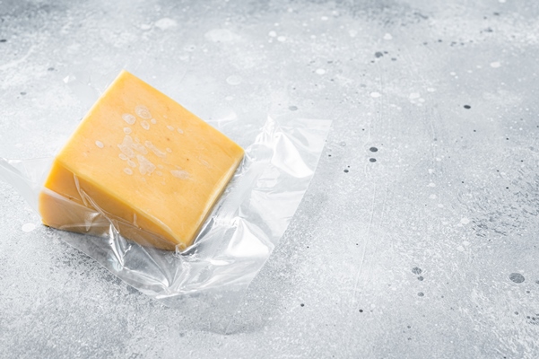 organic sharp cheddar cheese in vacuum packaging gray background top view copy space - Питание в походе