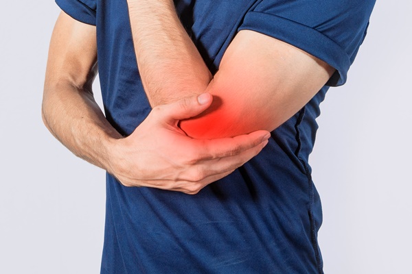 person with elbow pain concept of a man with rheumatism elbow pain man massaging sore elbow man with elbow cramp - Использование в пищу огородной и дикорастущей зелени