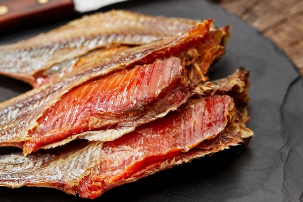 salted sundried roach with roe and knife on slate serving board - Вобла на пару