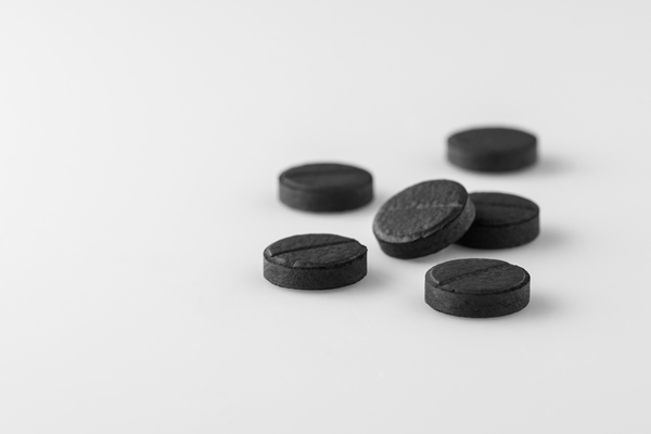 several black medical activated charcoal pills on white background isolated - Организация трапезы в походе: хранение продуктов, походная кухня, утварь, меню