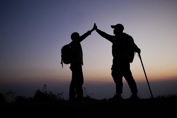 silhouette of teamwork helping hand trust help success in mountains hikers celebrate with hands up help each other on top of mountain and sunset landscape - Питание в походе