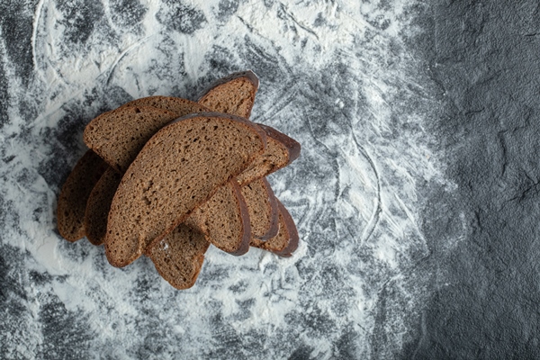 top view of sliced brown bread on flour background - Меню армейской кухни царской России